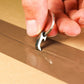 Hand using compact Gear Carry keychain tool to open taped cardboard box