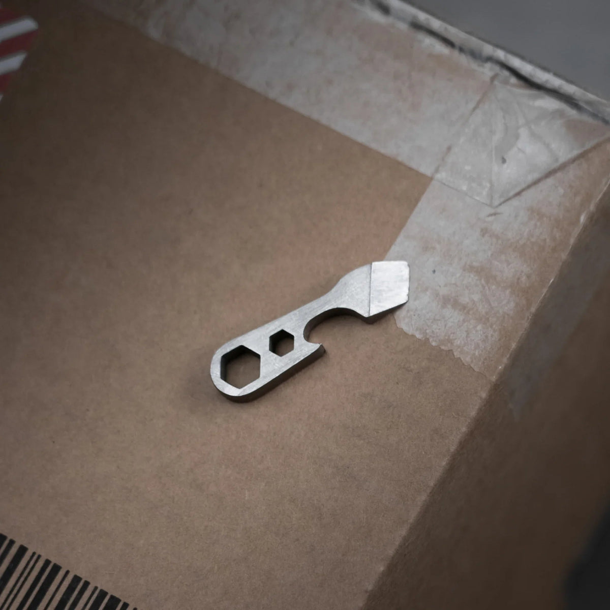 Compact metal multi-tool for everyday carry on a cardboard box, Gear Carry essentials