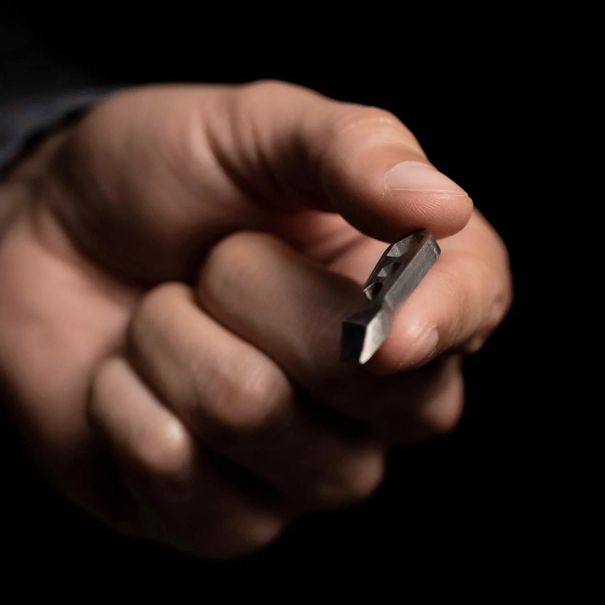 Hand holding compact metal pry bar, minimalist everyday carry tool by Gear Carry