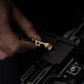 Hand using a compact brass multi-tool on a black metal gear accessory, Gear Carry EDC