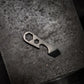 Compact metal multi-tool with hex and pry features on a dark textured surface, Gear Carry accessory