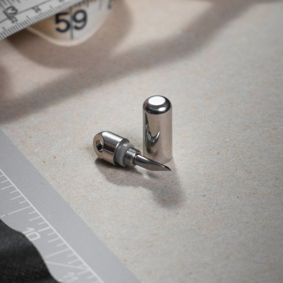 Compact stainless steel utility blade with cap on desk, Gear Carry everyday essential